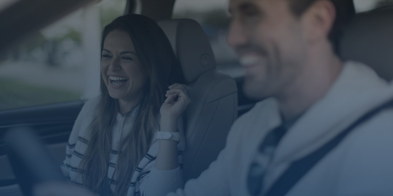 Man & Women Driving In Car Laughing.
