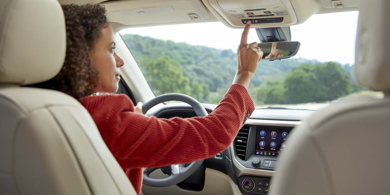 A driver pressing the OnStar button.